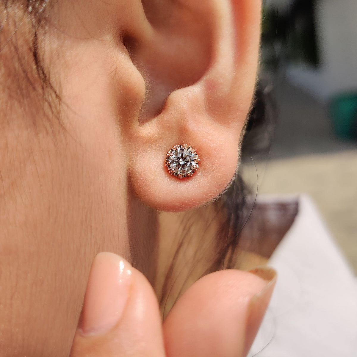 Round diamond earrings set in rose gold.