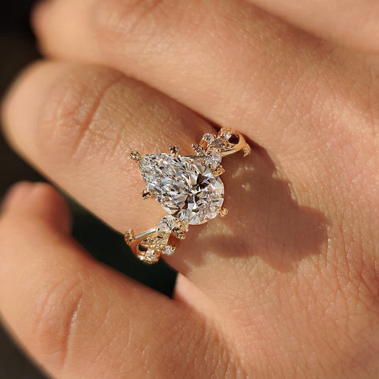 Filigree ring design with pear diamond center stone.