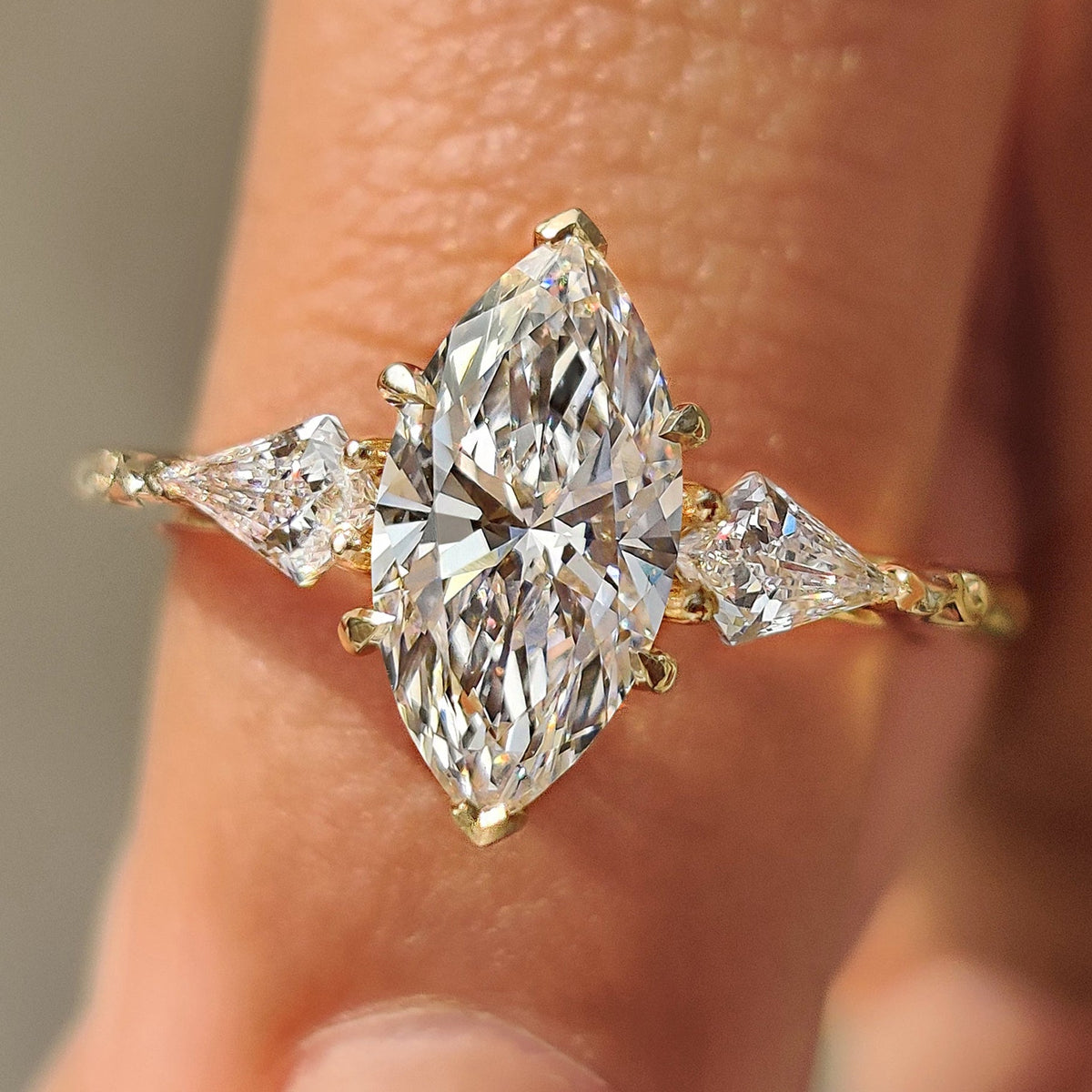 Marquise diamond ring with kite side stone in three stone diamond style