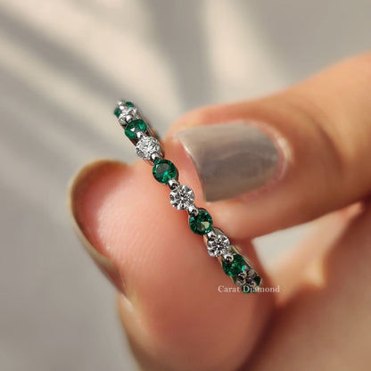 Emerald and diamond wedding band with round cut green emeralds.