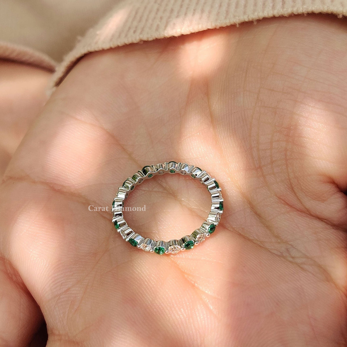 Carat Diamonds wedding band featuring emeralds and diamonds.