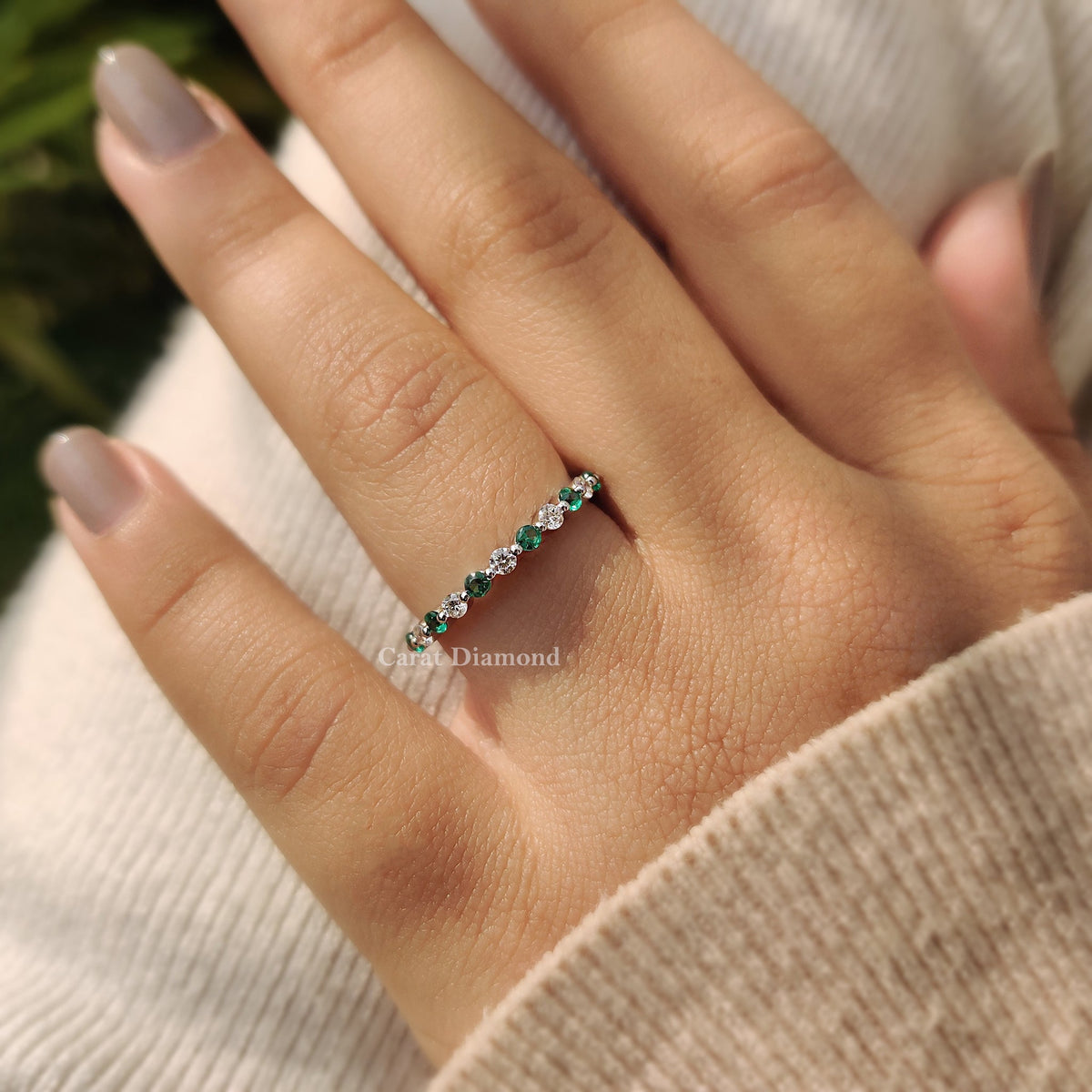 Elegant emerald and diamond band in white gold.