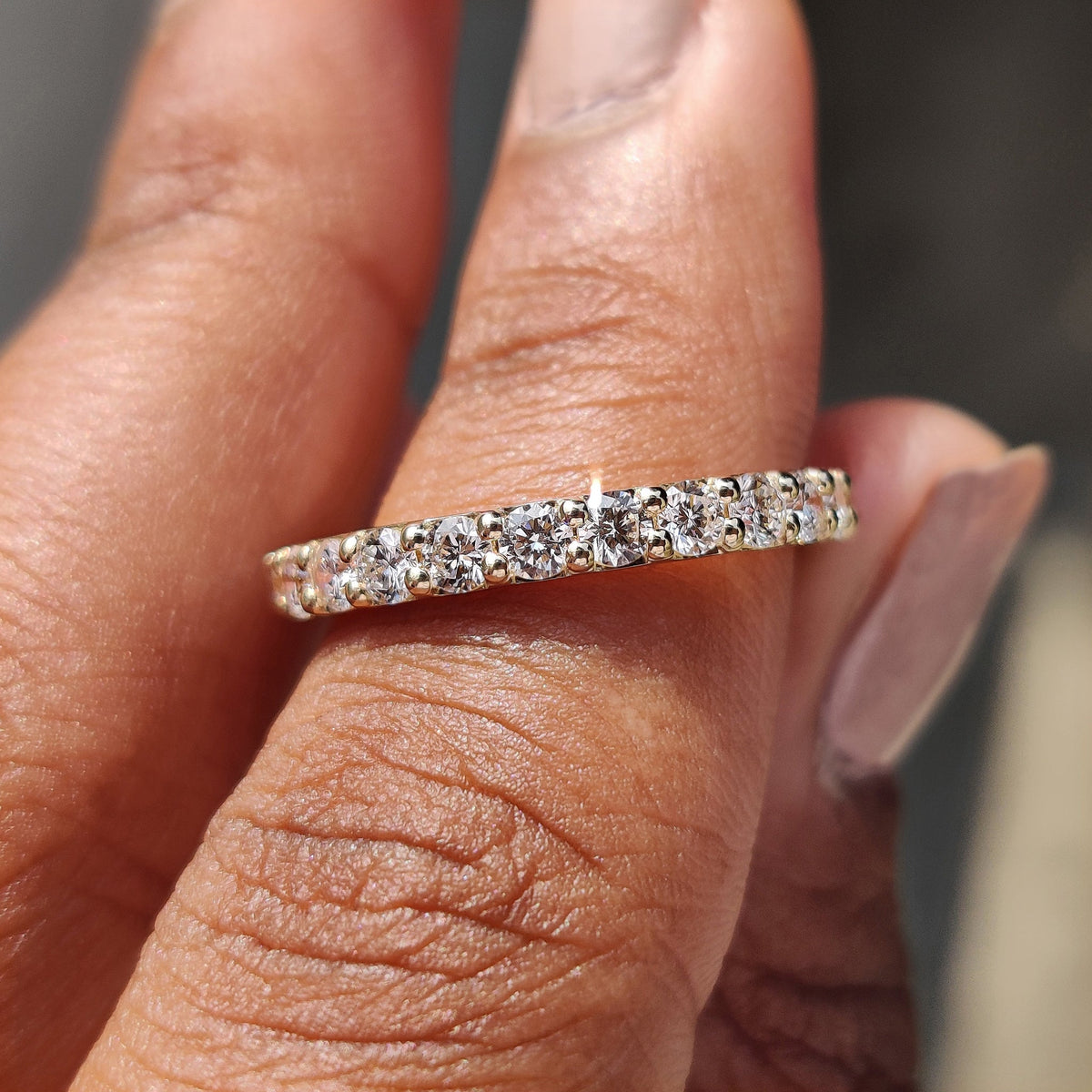 Yellow gold wedding band placed on a soft velvet surface.