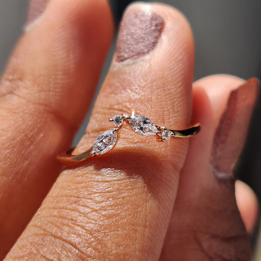 Marquise and round wedding band placed on a fabric tray.