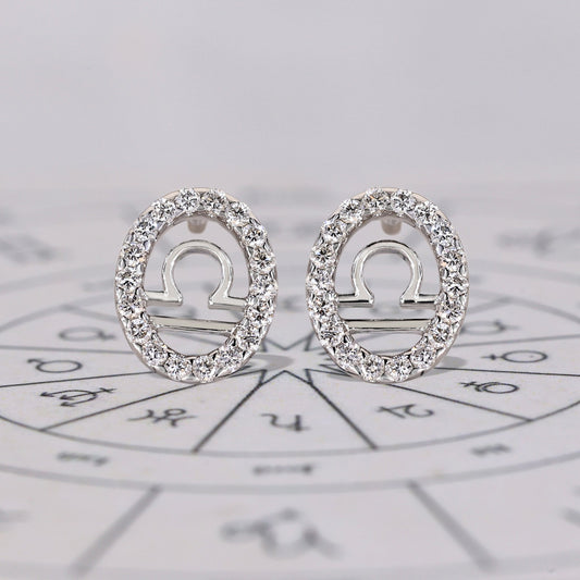 Libra earrings in white gold with round diamond halo studs.