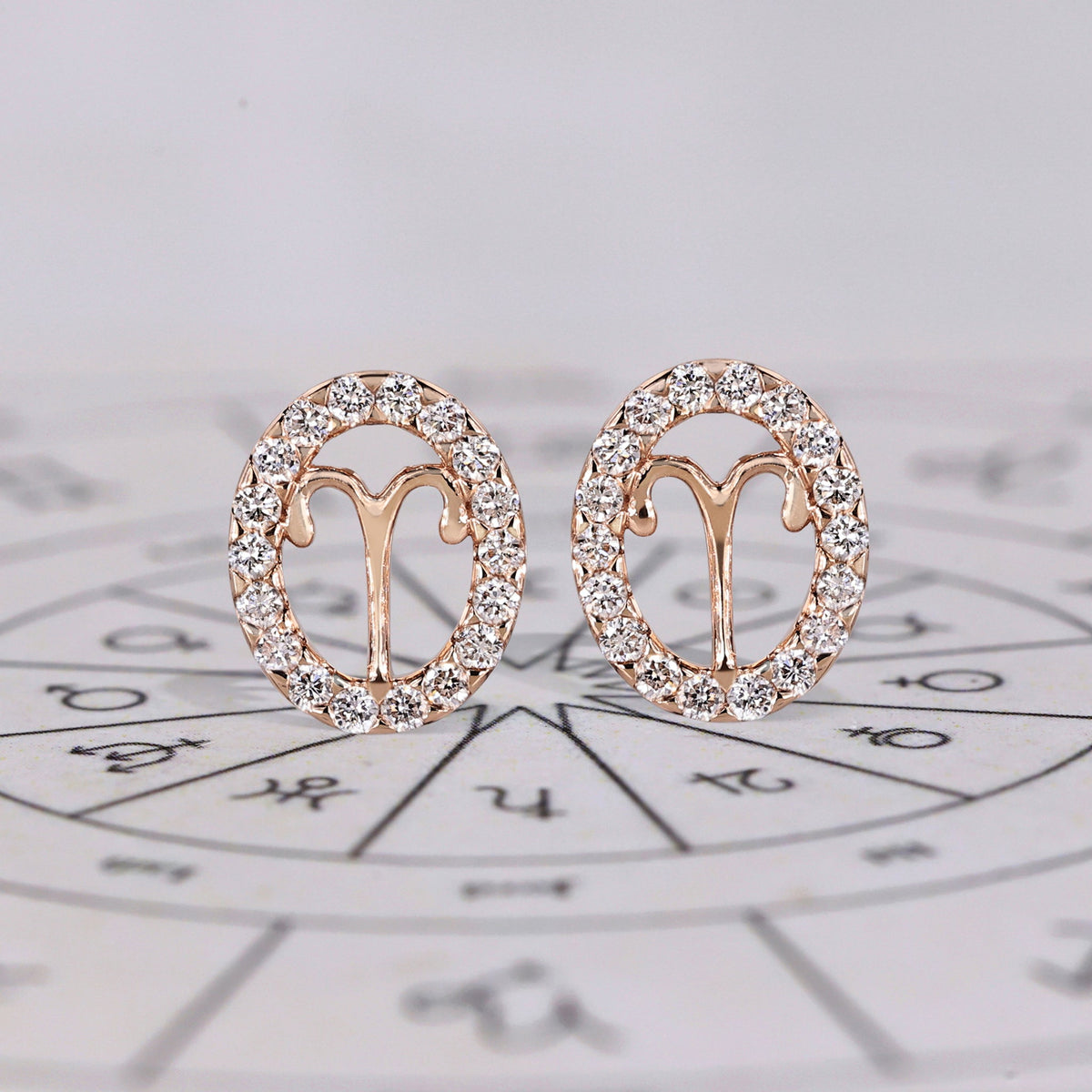 Aries earrings in rose gold with round cut halo diamonds.