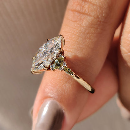 Marquise diamond ring with green marquise side accent stone.