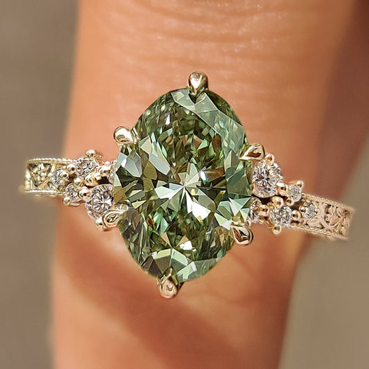 Green oval engagement ring with round side stones